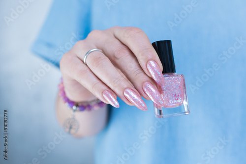 Woman's hands with long nails and a light pink color nail polish