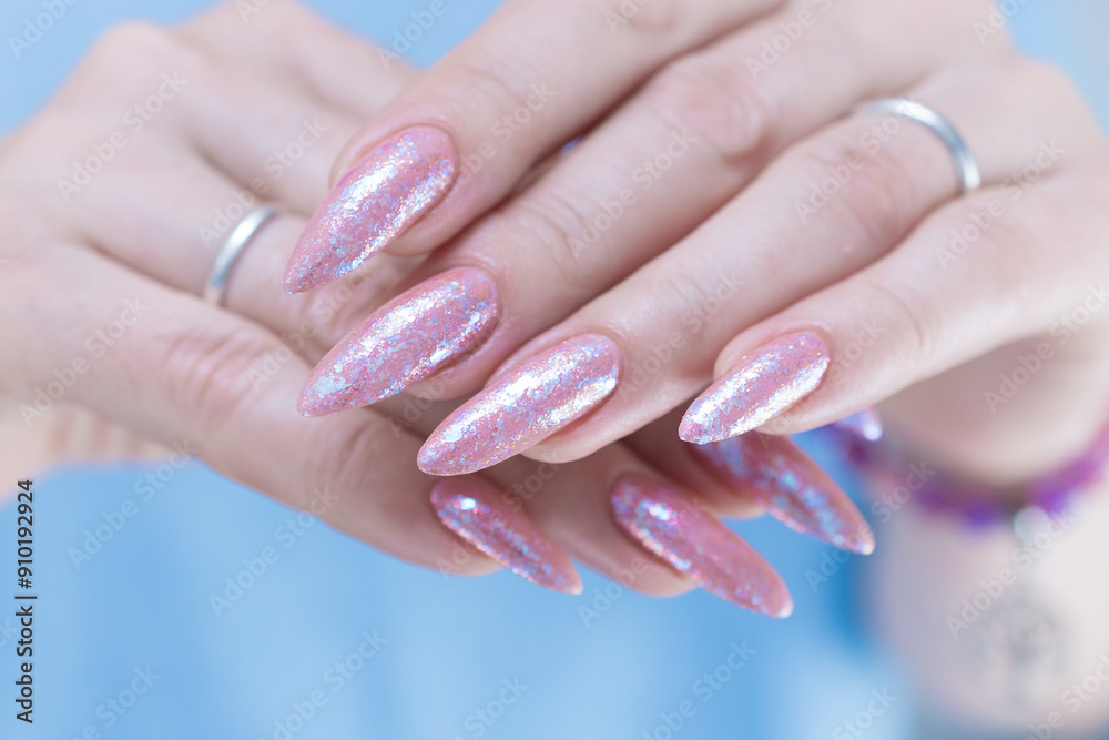 Woman's hands with long nails and light pink color nail polish Woman's hands with long nails and light pink color nail polish