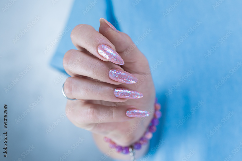 Woman's hands with long nails and light pink color nail polish Woman's hands with long nails and light pink color nail polish