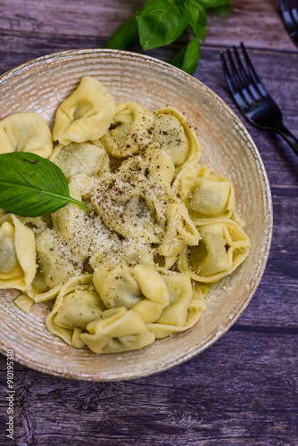 Home made Italian Tortelloni bolognese with parmesan cheese filled with beef , tomato and mozzarella cheese, decorated with fresh basil