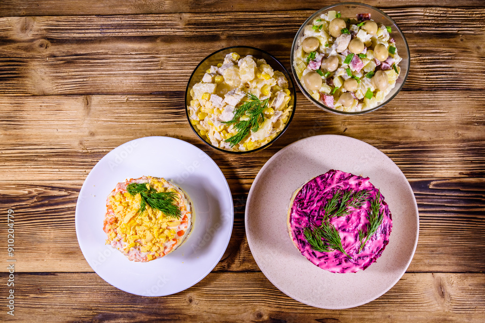 Set of festive mayonnaise salads on wooden table. Top view Set of festive mayonnaise salads on wooden table. Top view