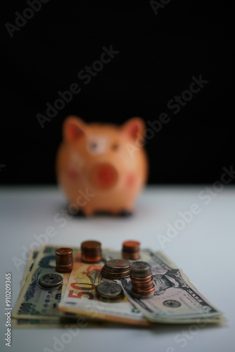 Wallpaper Mural Vertical photo of several dollar, euro and yen bills surrounded by coins of different currencies with a piggy bank out of focus in the background as a concept of saving and buying foreign currency Torontodigital.ca