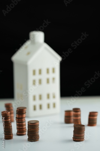 Wallpaper Mural Vertical photo of stacked coins of different currencies in front of a house Torontodigital.ca
