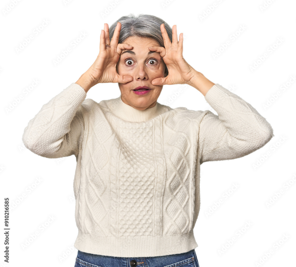 Caucasian mid-age female on studio background keeping eyes opened to find a success opportunity. Caucasian mid-age female on studio background keeping eyes opened to find a success opportunity.
