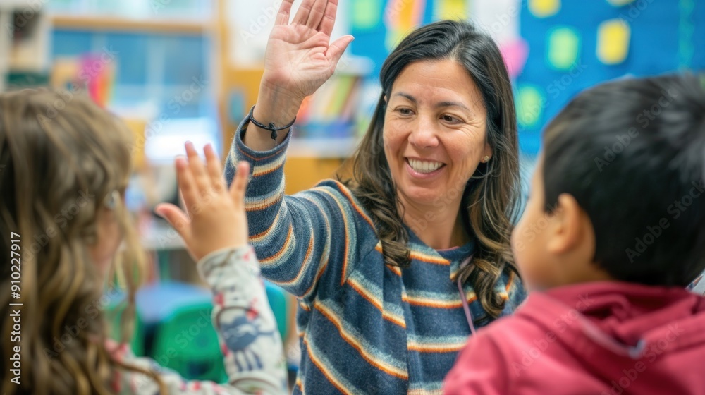 Obraz premium Happy teacher and schoolgirl giving high five during class at school.