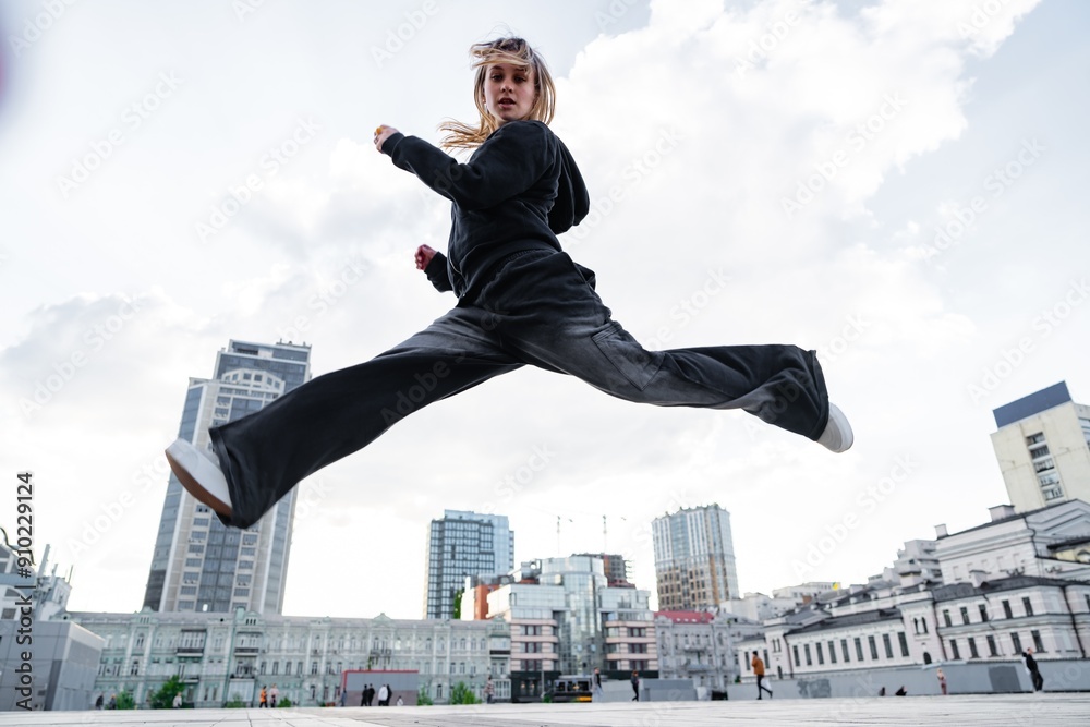 Dynamic Urban Dance Performance By a Young Woman in a City Square During Daylight Dynamic Urban Dance Performance By a Young Woman in a City Square During Daylight