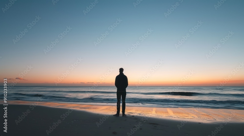 Solo traveler standing on a beach at sunset, looking out over the ocean. Solo traveler standing on a beach at sunset, looking out over the ocean.