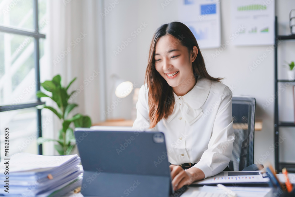 Young asian businesswoman is smiling while working remotely from her home office Young asian businesswoman is smiling while working remotely from her home office