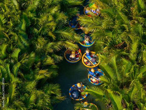 Aerial view of a coconut village basket boat tour. Palms forest in Hoi An ancient town, Cam Thanh, Vietnam. Tourists having an excursion and fun in Thu Bon river. photo