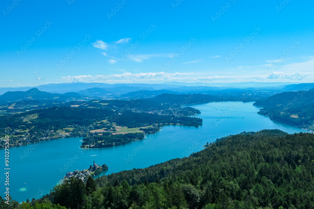 Aerial panoramic view of Lake Wörthersee seen from Pyramindenkogel in Carinthia, Austria. Serene turquoise waters, lush green forests and rolling hills of Austrian Alps. Charming lakeside village Aerial panoramic view of Lake Wörthersee seen from Pyramindenkogel in Carinthia, Austria. Serene turquoise waters, lush green forests and rolling hills of Austrian Alps. Charming lakeside village