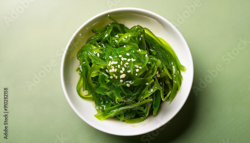 Green seaweed salad in white plate. Tasty food. Delicious and healthy dish. Close-up. Flat lay photo