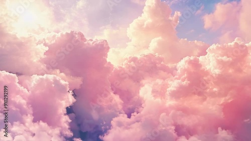 Flying through fluffy pink clouds in sunrise sky. Scenic aerial view. Tranquil sky and sugar cotton cloudscape concept. Dreamy and ethereal