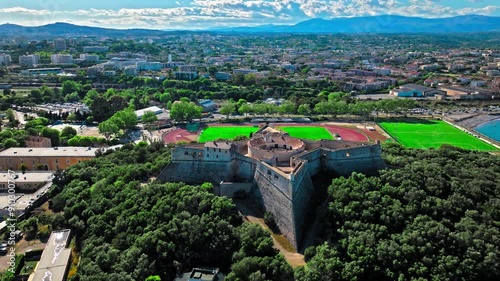 Drone view of Historical landmark star-shaped fort of four arrow-head-shaped bastions in Antibes.  Castle with a panoramic view of Le Fort Carré and scenic view of Port Vauban on French Riviera.
