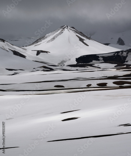 Принти на полотні A beautiful, snow, triangle mountain of the landmannalaugar highland, Iceland, is illuminated by the light through thick clouds