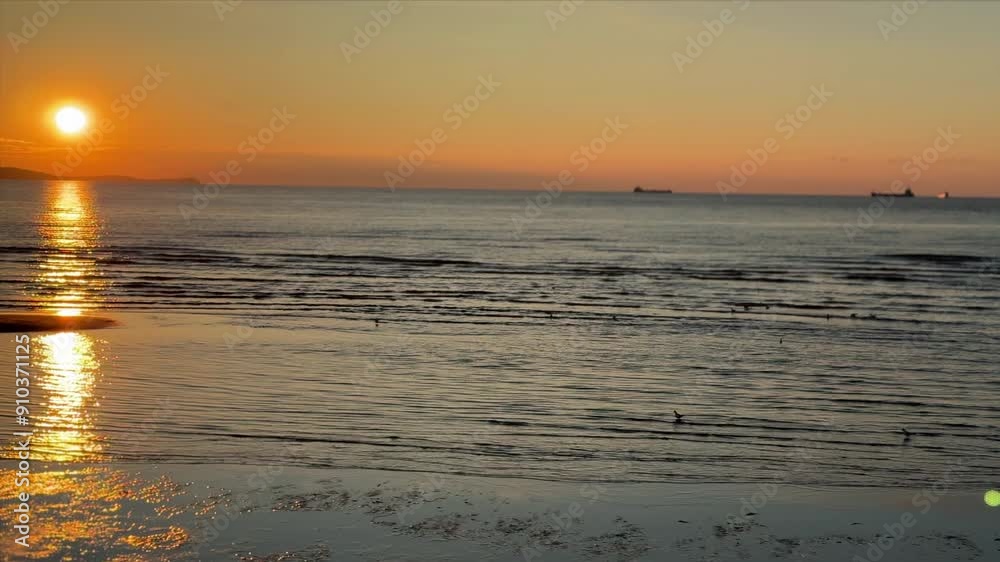 Sunset over the sea. The setting sun over the calm sea. Evening time on the beach by the sea. Sunset over the sea. The setting sun over the calm sea. Evening time on the beach by the sea.