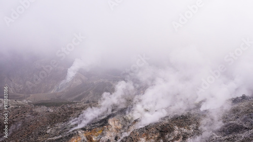 Volcanic landscape with billowing steam rising from vents, a raw display of geothermal activity photo