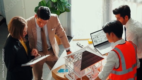 Top view of professional architect engineer team inspect house model while manager holding blueprint and asking about building construction. Group of diverse engineer working together. Alimentation.