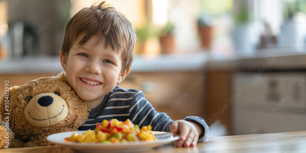 Cute little child sitting by the table eating their meal with a teddy. Feeding a kid healthy food. Cute little child sitting by the table eating their meal with a teddy. Feeding a kid healthy food.