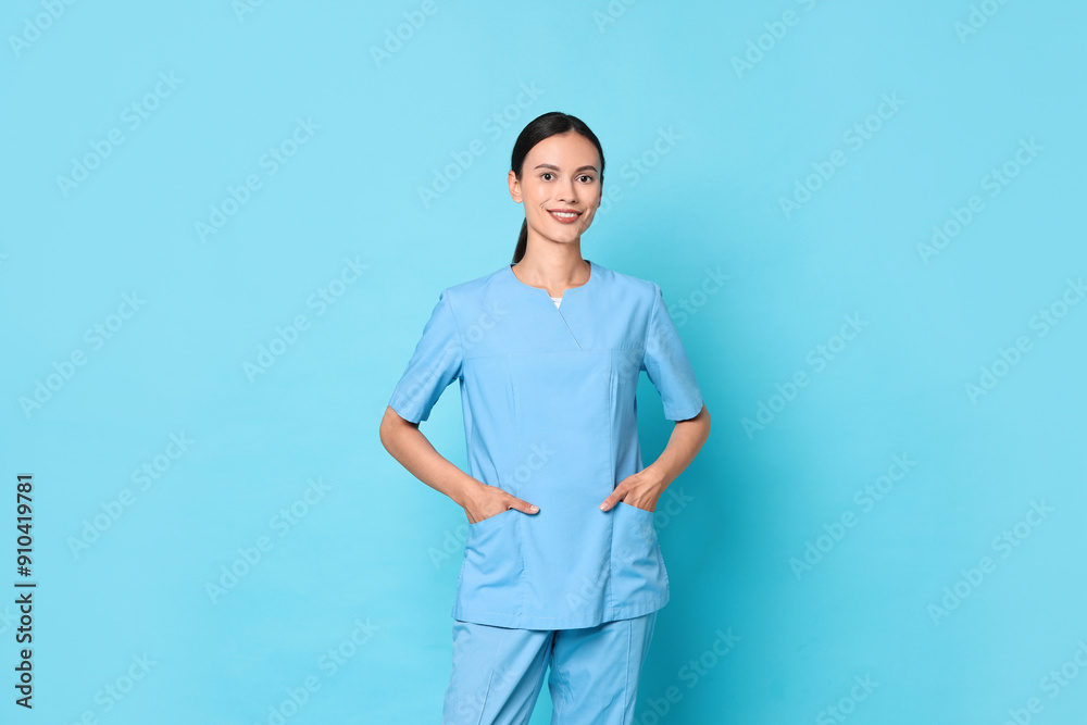 Smiling nurse in uniform on light blue background Smiling nurse in uniform on light blue background
