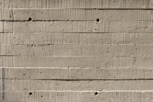 Concrete wall showing the wood imprint pattern of the planks it was formed from.
