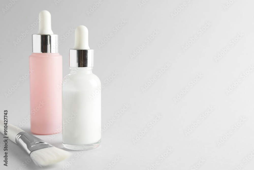 Bottles of chemical peel and brush on light background, space for text. Peeling procedure Bottles of chemical peel and brush on light background, space for text. Peeling procedure