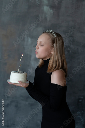A beautiful girl with a bento cake blows out a candle. The concept of a holiday, a birthday with space to copy