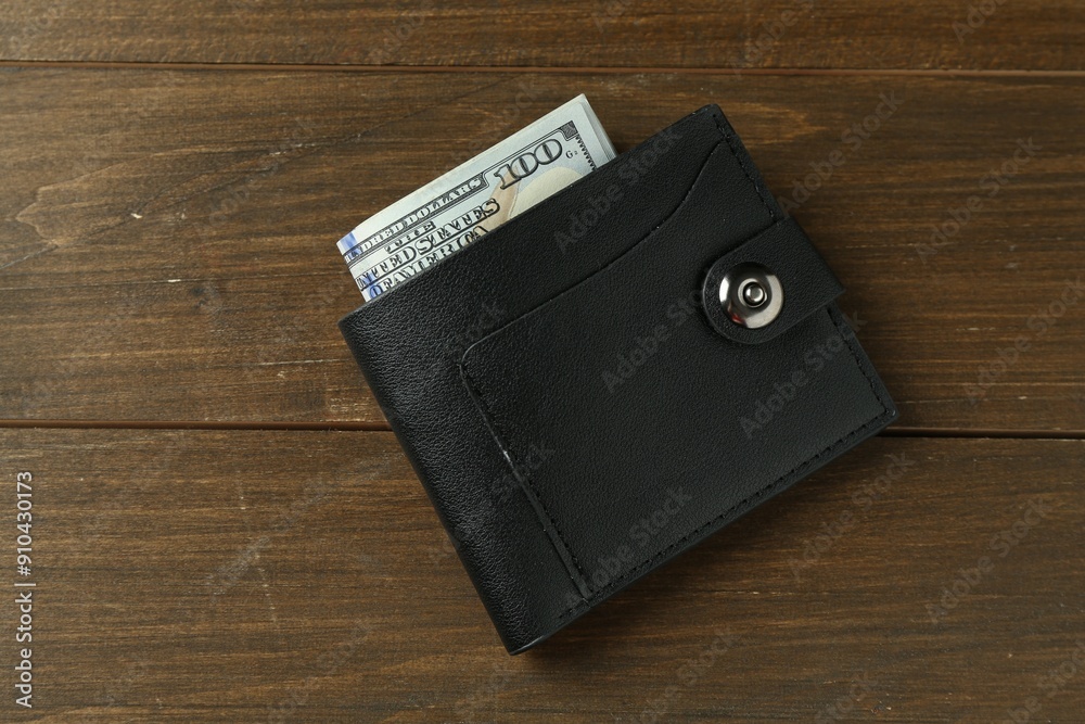 Leather wallet with dollar banknotes on wooden table, top view Leather wallet with dollar banknotes on wooden table, top view