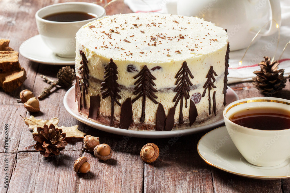 Tea party with Black Forest cake. Cherry cake decorated with chocolate fir trees on a light background.