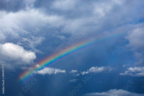 rainbow in blue sky with clouds