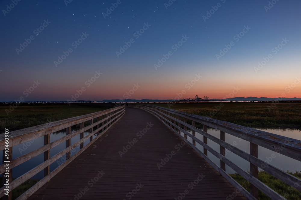 Starry twilight after sunset over a wooden walkway to the ocean