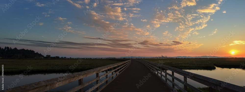 Wooden walkway leading to the seaport at sunset