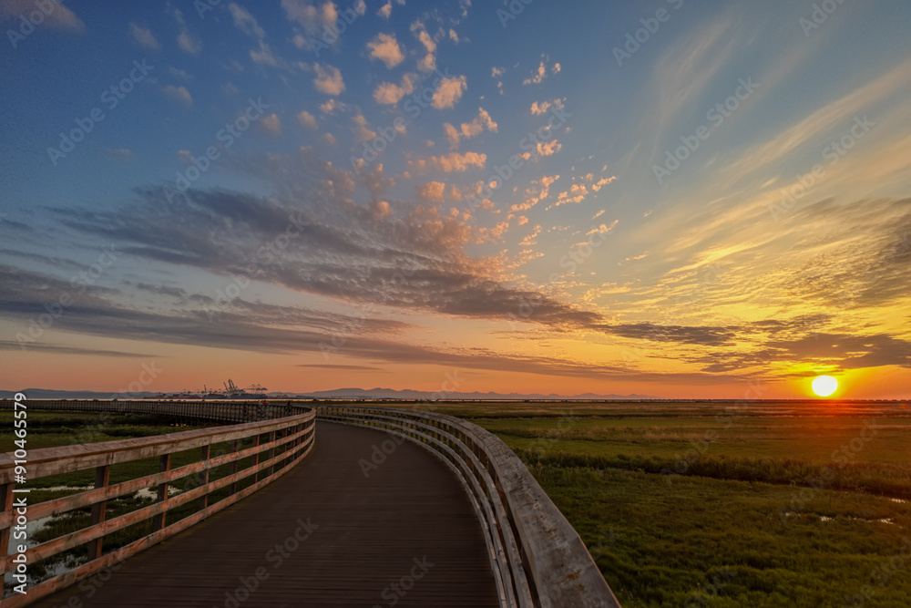 Fototapeta premium Wooden walkway leading to the seaport during the summer sunset