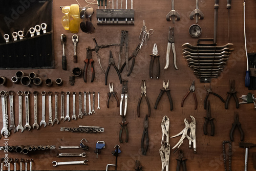 A large set of wrenches hangs on the wall in the workshop