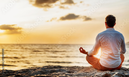 man sitting, meditating in yoga position near ocean beach in beautiful sunrise peaceful time
