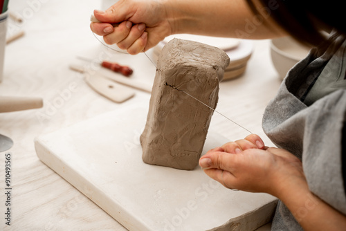 Fotografía Cutting off the necessary piece of clay before forming a pottery product