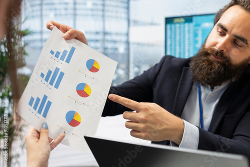 Financial advisor in office providing economic services to customers, showing them diagrams, close up shot. Consultant talks with m other and daughter about their banking accounts, giving advice photo