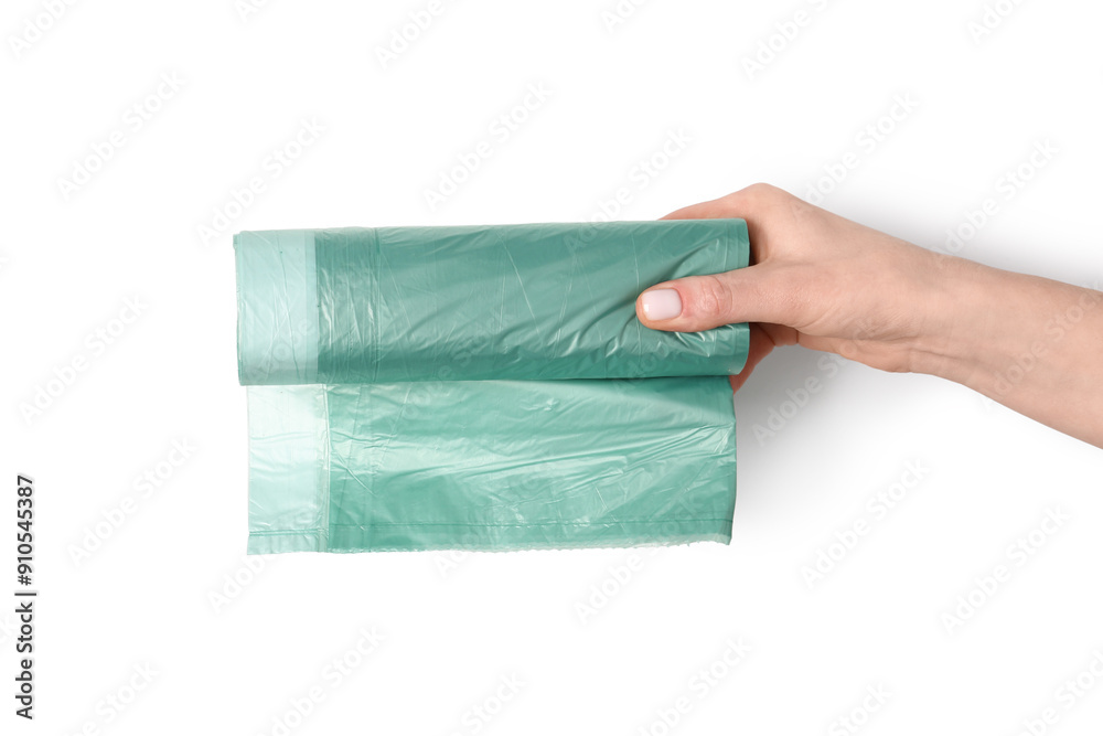 Fototapeta premium Female hand holding roll of garbage bags on white background