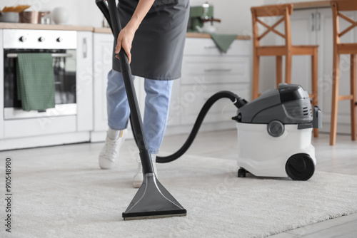 Young woman vacuuming carpe...