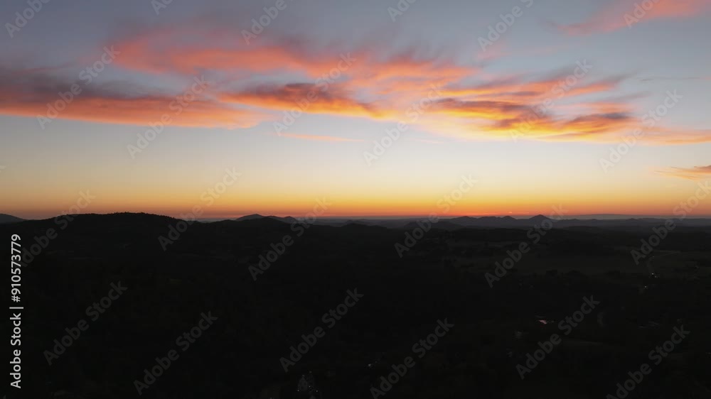 Aerial view of the sun setting over the Pacific Ocean in the distance with colorful sky during dusk Aerial view of the sun setting over the Pacific Ocean in the distance with colorful sky during dusk
