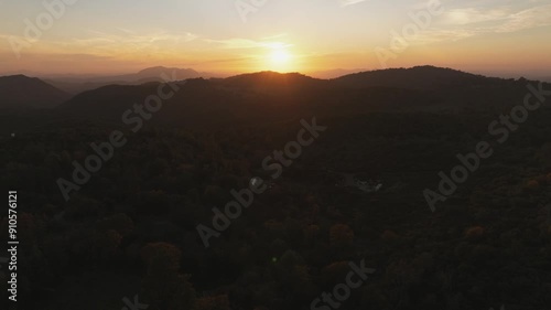 Aerial view of the sun setting over the mountains in Southern California at dusk with colorful sky