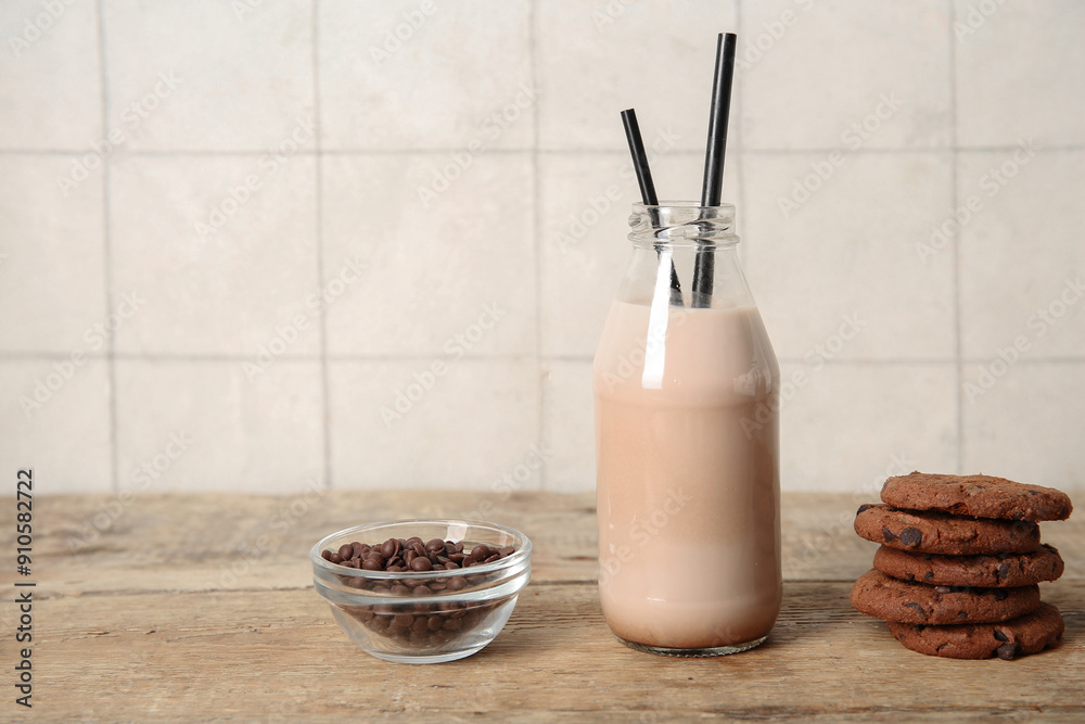 Bottle of sweet chocolate milk and tasty cookies on wooden table Bottle of sweet chocolate milk and tasty cookies on wooden table