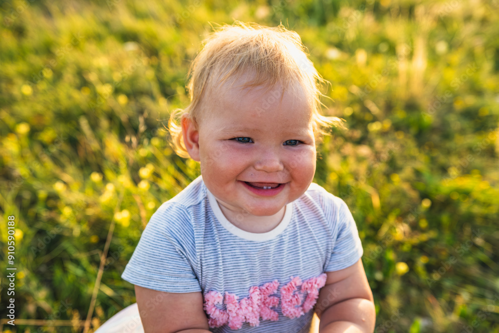 Happy Baby Enjoying Sunshine While Playing Outdoors in a Green Field Happy Baby Enjoying Sunshine While Playing Outdoors in a Green Field