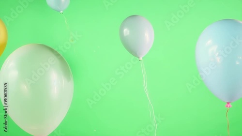 Soft and delicate balloons floating aimlessly as if lost in their own world. Green screen chromakey photo