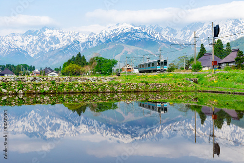 残雪の山々を背景に駆け抜ける大糸線