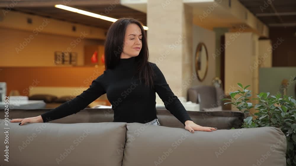 A woman in a store chooses a new sofa in a store A woman in a store chooses a new sofa in a store