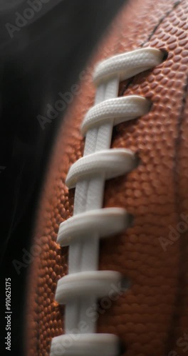 Football ball macro rotating with smoke in studio slow motion, vertical view