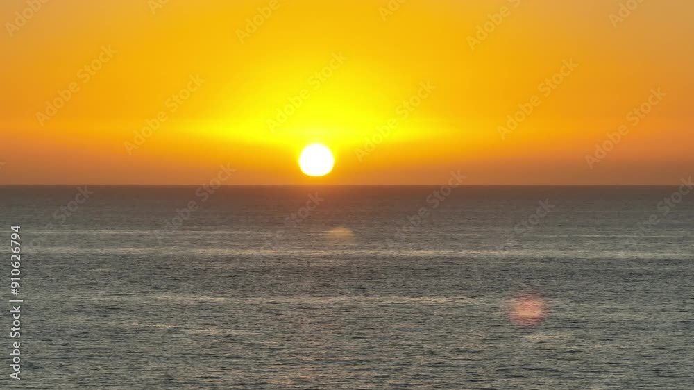 Aerial view of the sun setting behind the Pacific Ocean with golden partly cloudy sunset sky in San Diego California Aerial view of the sun setting behind the Pacific Ocean with golden partly cloudy sunset sky in San Diego California