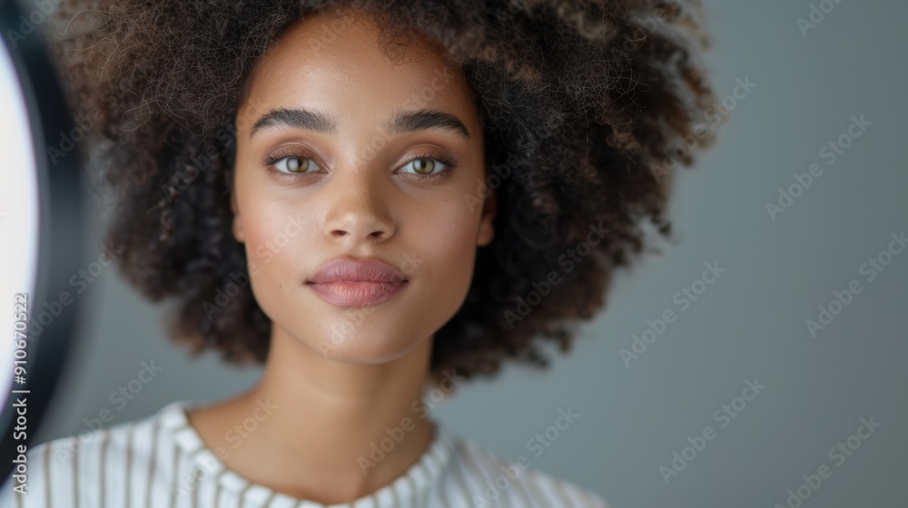 A stunning portrait of a young woman with curly hair, displaying confidence and natural beauty against a soft background. A stunning portrait of a young woman with curly hair, displaying confidence and natural beauty against a soft background.