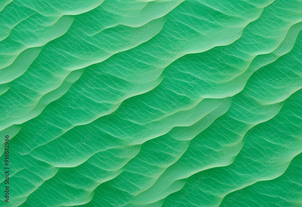 Obraz premium An abstract pattern of green waves resembling water surface, with a textured appearance a vibrant green color with a marbled effect, resembling jade. The light creates movement in the design.