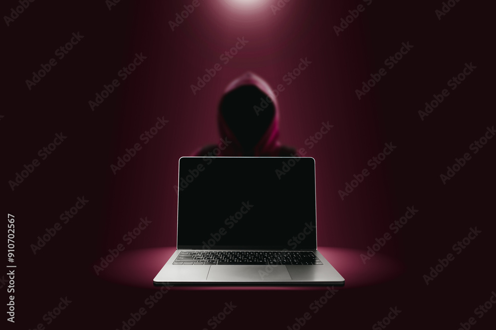 Crime and attack technology concept by hacker , Grey laptop with black blank screen and red hacker blurred in a red darkness background with lights shining down from above. Crime and attack technology concept by hacker , Grey laptop with black blank screen and red hacker blurred in a red darkness background with lights shining down from above.
